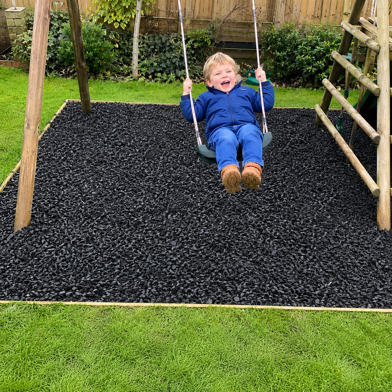 Small child on swing set above rubber chippings