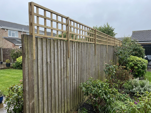 UK garden fence raised with a timber trellis topper above existing closeboard panels — boundary fence height extension