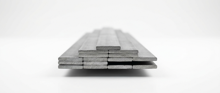 Stack of steel flat bar lengths on a white background