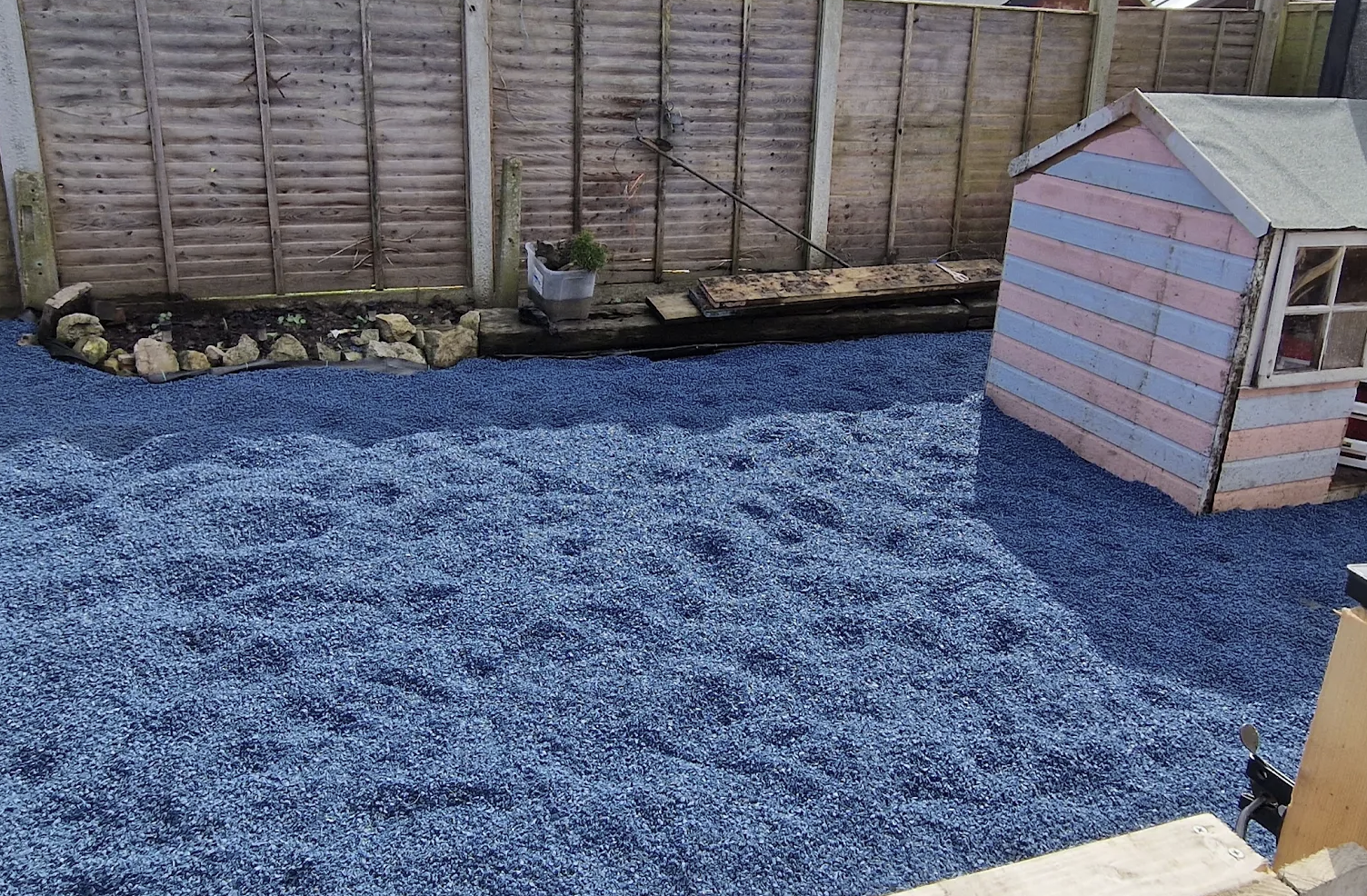 Blue playground rubber chippings installed in garden play area