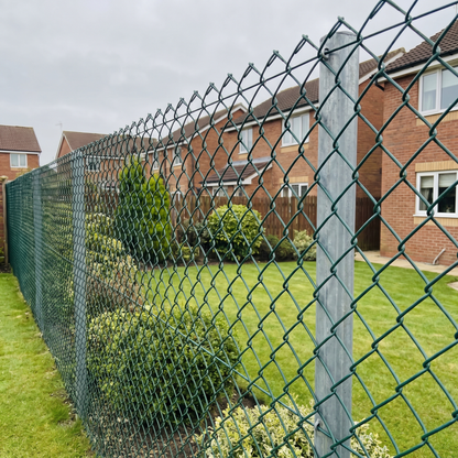 Green PVC-coated chain link fence along a UK residential garden boundary
