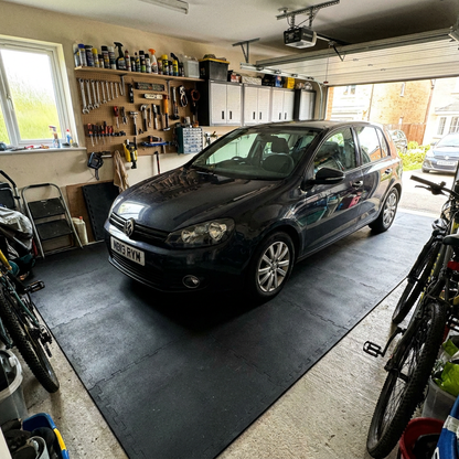Smooth black rubber garage flooring in a UK home garage with a car parked on it