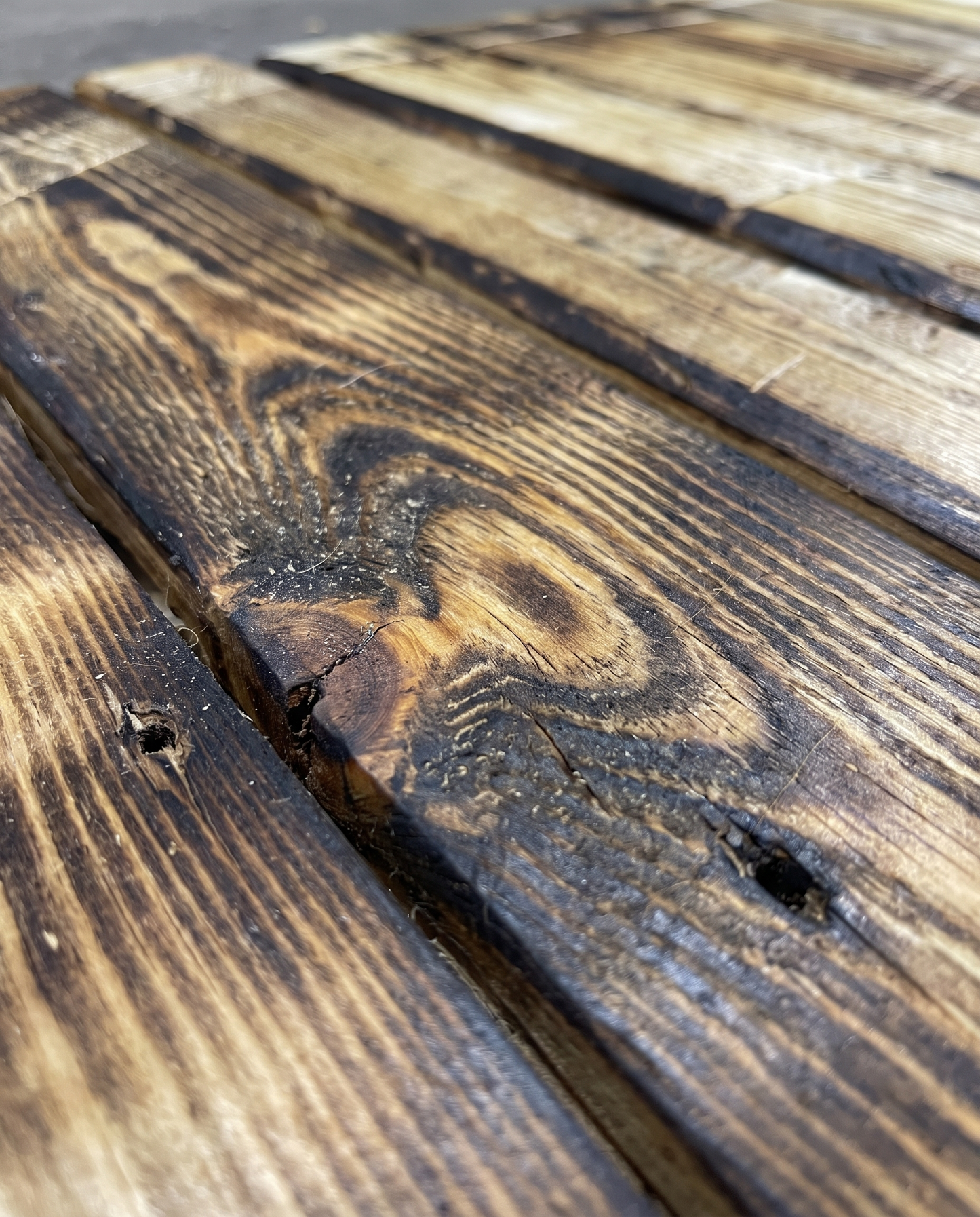 Close-up of hand-scorched charred pallet wood texture