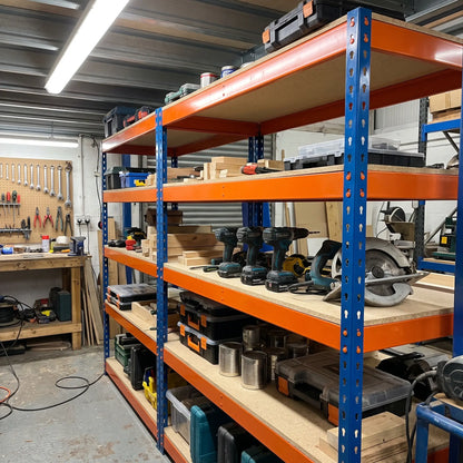 Boltless workshop shelving holding power tools and timber, orange and blue steel garage racking