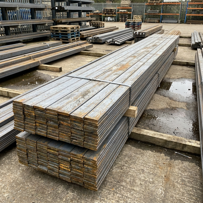 Stack of mild steel flat bar 6m lengths in a UK steel yard