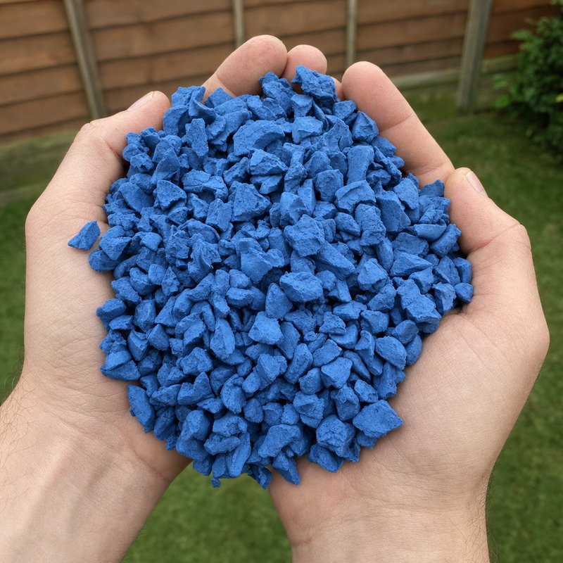 Hands holding Summer Blue 20mm rubber chippings showing chip size, texture and authentic recycled rubber colour